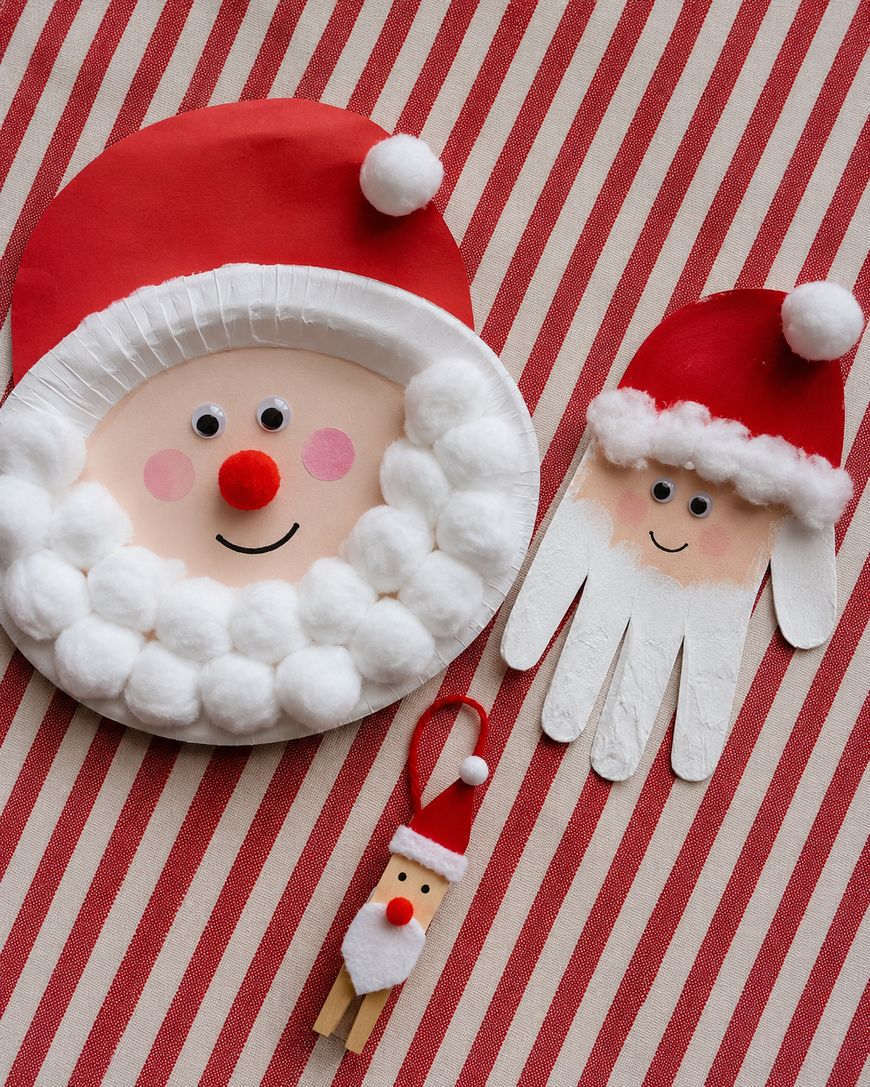 Three Santa Claus crafts made from paper plates, cotton balls, a handprint cutout, and a clothespin, are displayed on a red and white striped background.